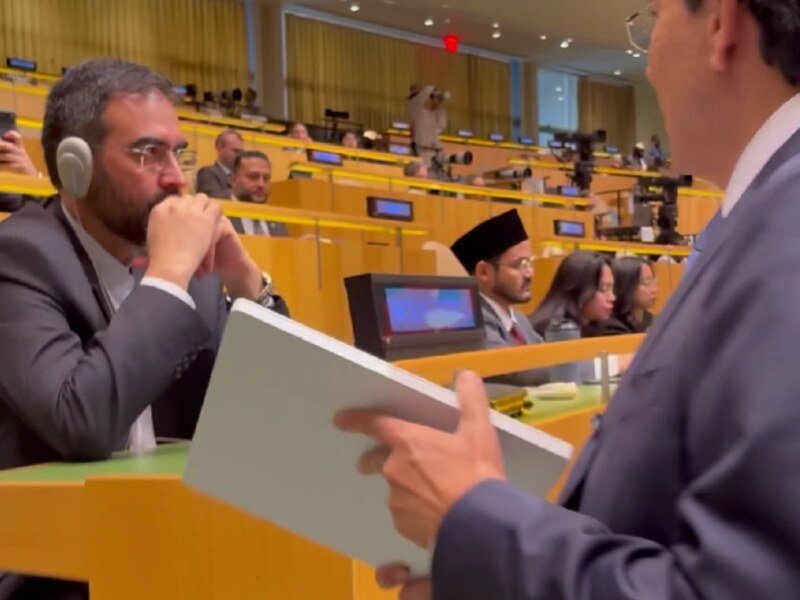 Momento en el que el representante permanente de Israel ante las Naciones Unidas se acerca y le ofrece una terminal Starlink al integrante de la delegación iraní.